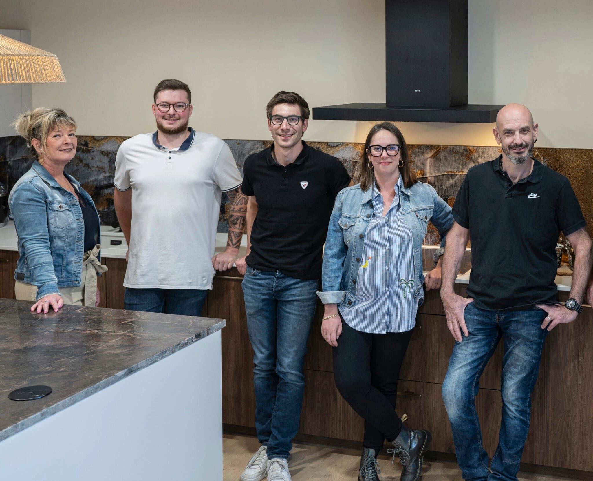 L'équipe Cuisinicime réunie devant un îlot de cuisine dans le showroom d'Éteaux